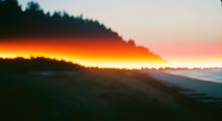 Obraz premium Dramatic sunset over a tranquil beach with silhouetted trees and ocean waves