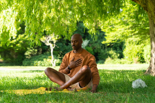 Black man practicing yoga,meditation in the park London
