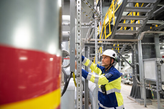 Industrial Worker Inspecting Equipment in a Modern Facility