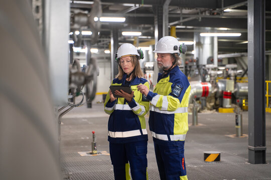 Technicians Using Tablet While Working At Power Plant