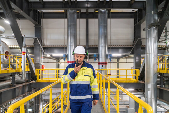 Worker Navigates Industrial Facility With Communication Device
