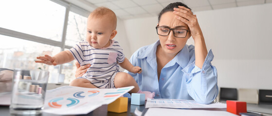 Stressed mother with her baby working in office