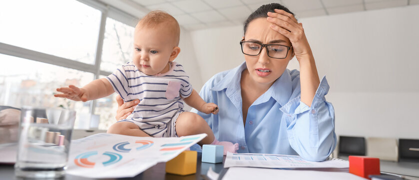 Stressed mother with her baby working in office