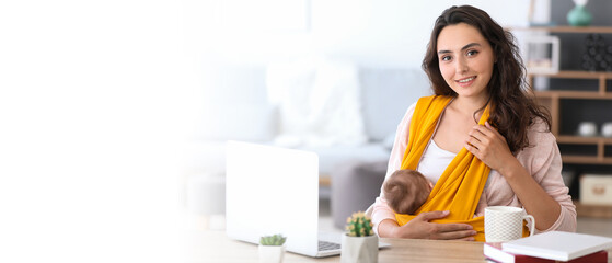 Young mother with little baby in sling working at home