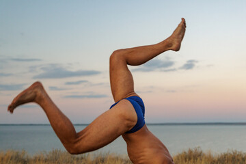 A Man Is Fooling Around Doing A Handstand In Nature