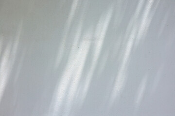 close up on white plain wall background texture with shadow of window from sunlight for ads and advertisement product such as cosmetic or content or goods design display concept