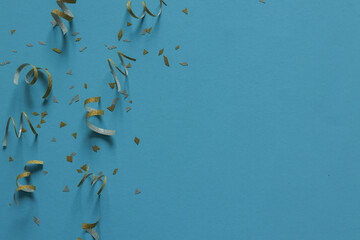 close up on group of gold color of rolling ribbon and confetti on teal background with copy space for christmas festival happy new year ,carnival , birthday and anniversary, concept design
