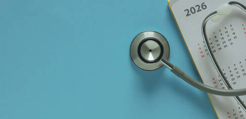 top view on stethoscope on calendar 2026 with over blue background for design about ads or banner of doctor appointment and health checkup following personal lifestyle concept