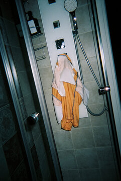 wet orange shorts for a man drying in a shower, 35mm film