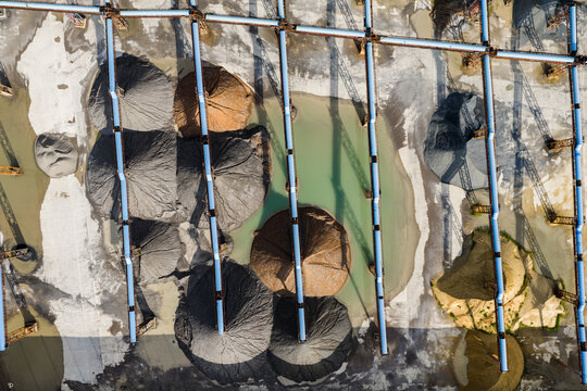 Top view of sand and gravel piles with conveyor belts in storage yard