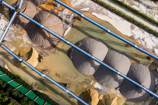 Top view of sand and gravel piles with conveyor belts in storage yard