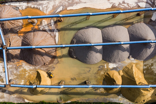 Top view of sand and gravel piles with conveyor belts in storage yard