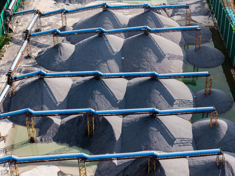Top view of sand and gravel piles with conveyor belts in storage yard