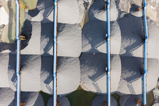 Top view of sand and gravel piles with conveyor belts in storage yard