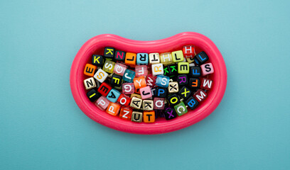 Overhead View of Multicolored Plastic Cube Letters on Blue Background