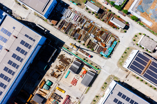 Aerial top view of crane loading steel onto truck in factory yard