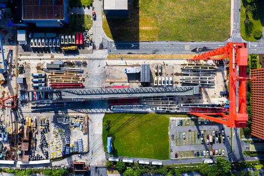 Aerial top view of gantry crane and construction materials in factory 
