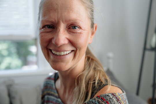 Smiling woman indoors showcasing happiness and crying for real