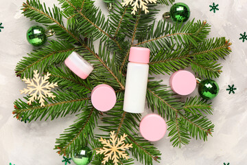 Beautiful composition with bottle, jars of cosmetic products and Christmas decorations on grunge background