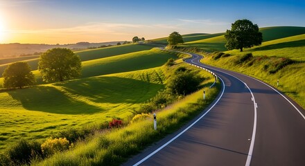 Road through rolling green hills at sunset