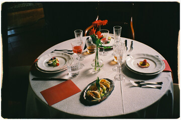 A restaurant table arranged with elegant tableware and gourmet dishes