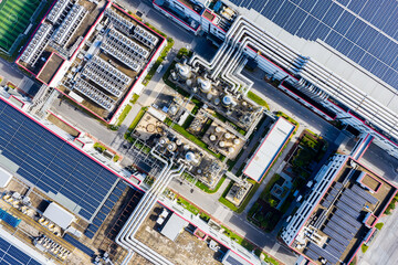 Aerial top view of industrial pipelines and solar panel rooftops