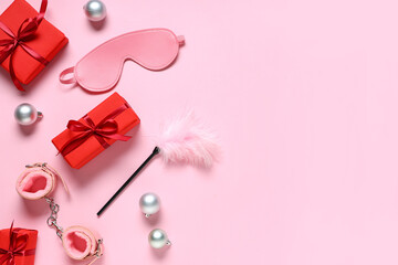 Composition with sex toys, gift boxes and Christmas decorations on pink background