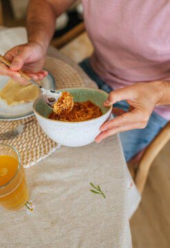 Hand serving shredded meat from ceramic bowl