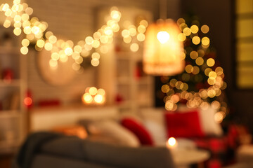 Interior of living room with glowing lamps decorated for Christmas celebration at evening, blurred...