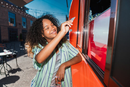 Smiling woman making card payment at food truck