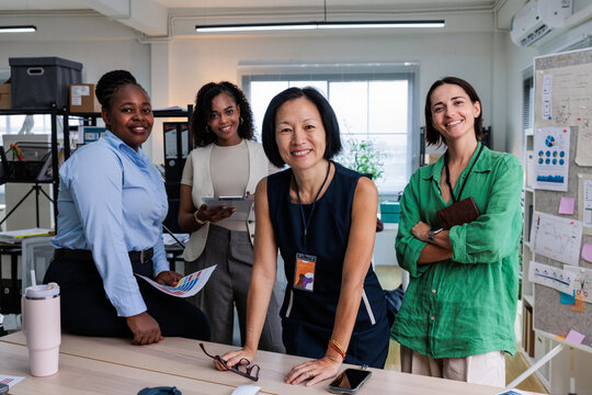 Diverse team of women smiling in a modern office.