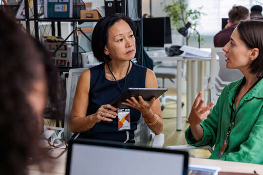 Businesswomen collaborate in a modern office setting.