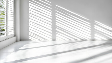 Obraz premium Bright sunlight creates shadow lines on white floor from window blinds, enhancing tranquility