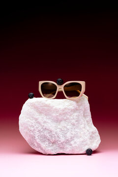 Sunglasses and blueberries on a piece of marble block
