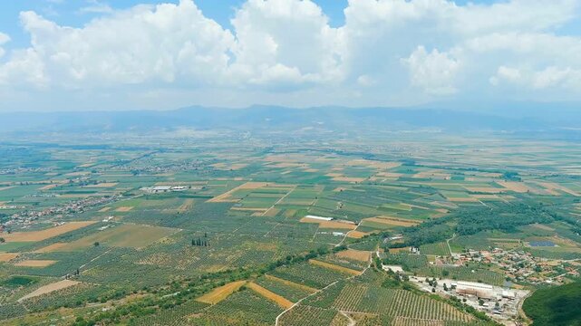 Lamia, Phthiotis, Greece. Panorama of the valley with fields. Olive trees, colorful fields. Summer, Cloudy weather. Drone footage