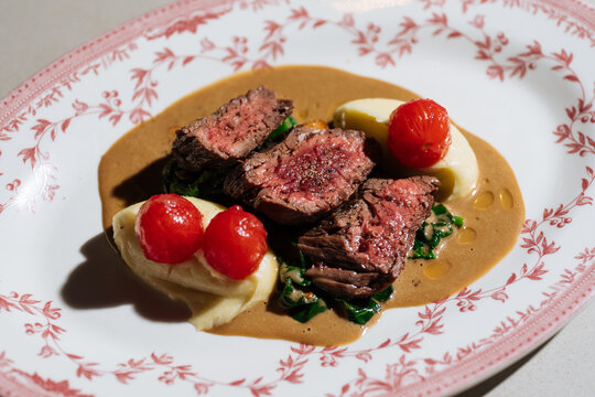 Medium-rare steak with mashed potatoes and cherry tomatoes - Powered by Adobe