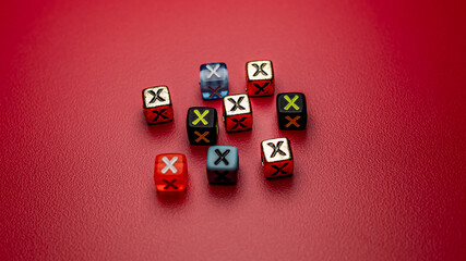 A scattering of small, multi-colored game dice featuring a prominent 'X' symbol, set against a deep...
