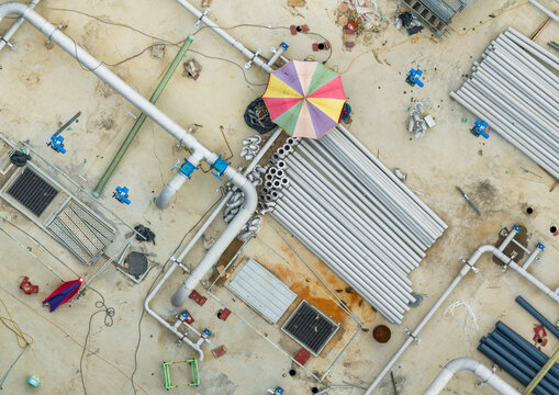 Aerial View of Industrial Construction Site with Pipes and Sunsh
