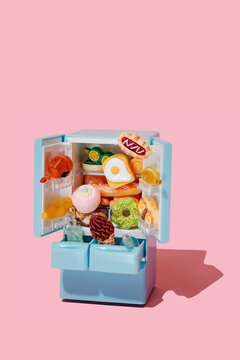 a blue toy fridge crammed with food and drinks