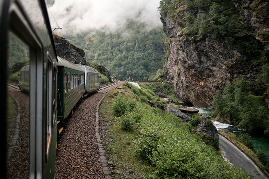 Fototapeta Scenic Train Ride Through Foggy Forest and Mountainous Landscape 