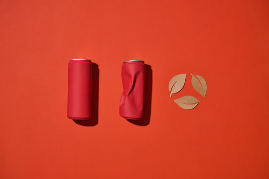 Recycling concept with red soda cans and a paper recycling symbol