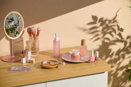 Cosmetic products and makeup tools on a wooden cabinet