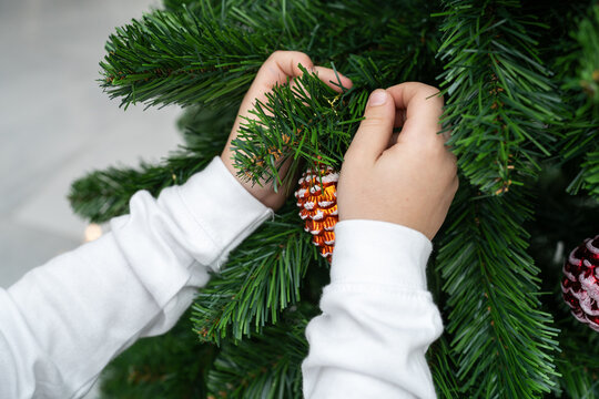 Child Decorating a Christmas Tree With Handmade Ornaments