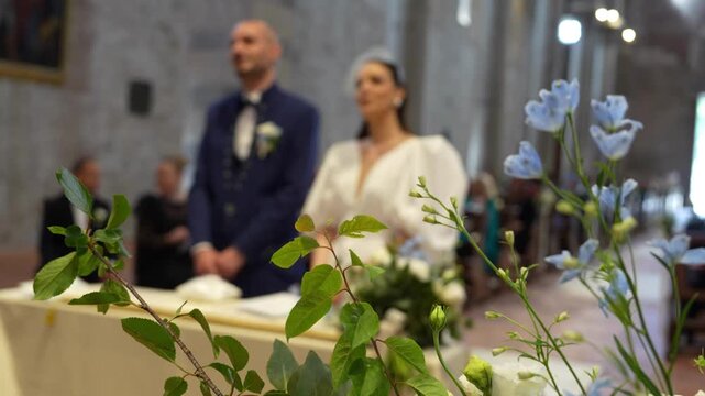 Elegant couple exchanging vows at the altar, surrounded by family and friends on their wedding day