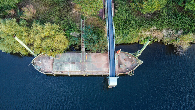 conveyor belt next to a river for an aggregate processing site