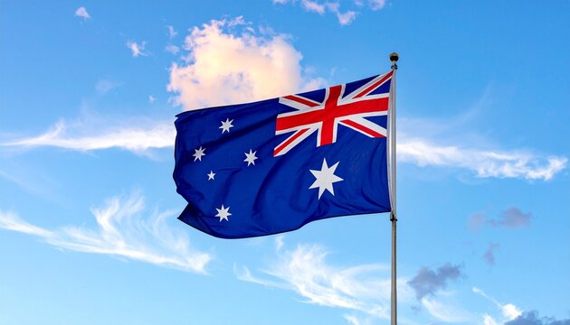 Australian national flag flying against a bright blue sky with scattered clouds