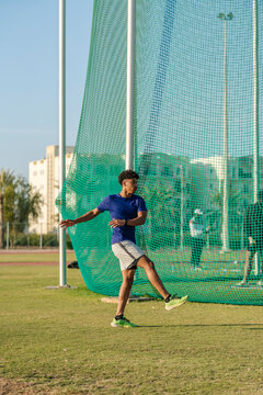 Young male athlete practicing discus throw in Oman
