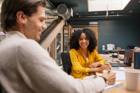 Colleagues sharing ideas in a modern office environment with laughs