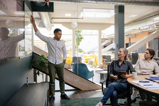 Contemplative professional standing in modern space with white board