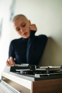 Young Woman Enjoying Music While Playing Vinyl Records at Home
